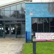 Entrance to Woolston Neighbourhood Hub with a banner reading "Save Woolston Community Hub" on the fence outside.