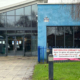 Entrance to Woolston Neighbourhood Hub with a banner reading "Save Woolston Community Hub" on the fence outside.